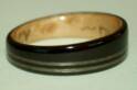 Grenadilla and birds eye maple wood ring with narrow and offset inlays of greyed maple. Tapered